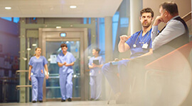 View inside of a hospital hallway with people in scrubs